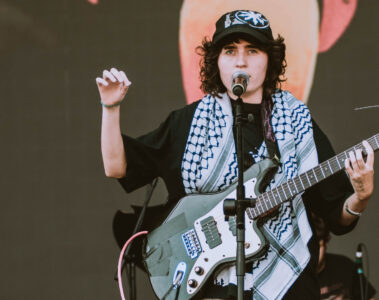 Sophia Chablau no Lollapalooza 2025 com keffiyeh palestino e guitarra, durante performance com protesto político.