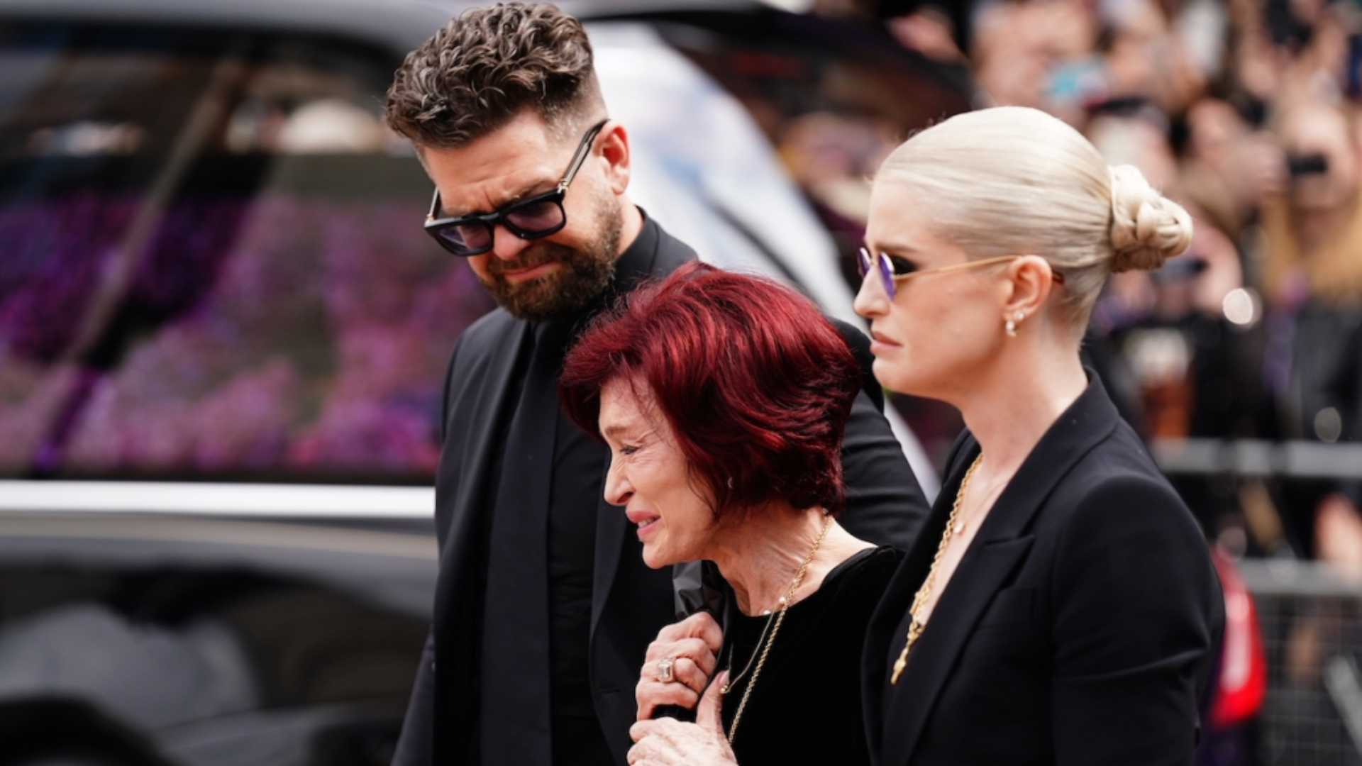 Sharon Osbourne chora ao lado dos filhos Jack e Kelly durante o cortejo fúnebre de Ozzy Osbourne em Birmingham.