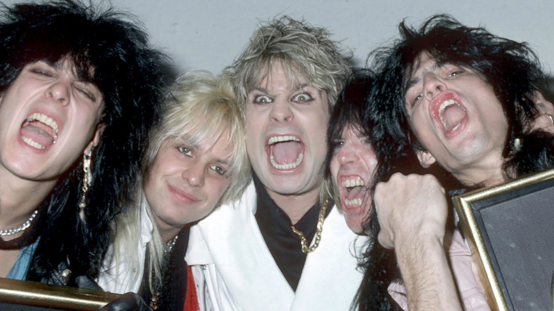Ozzy Osbourne e integrantes do Mötley Crüe nos anos 1980, gritando e celebrando juntos