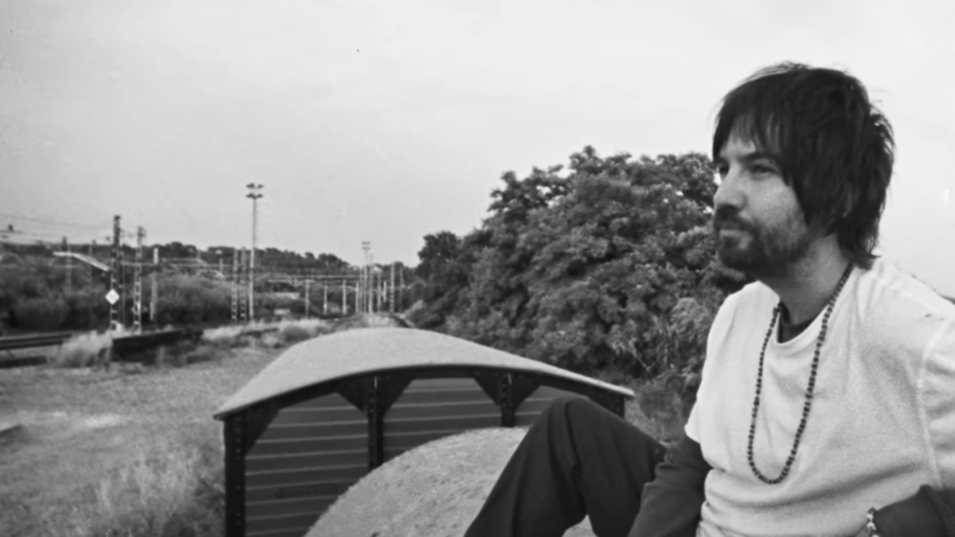 Kevin Parker sentado em um vagão de trem em imagem promocional do single End of Summer do Tame Impala