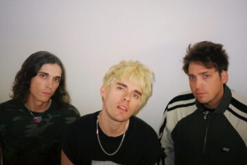 Integrantes da banda Waterparks posando para foto promocional com expressão séria.