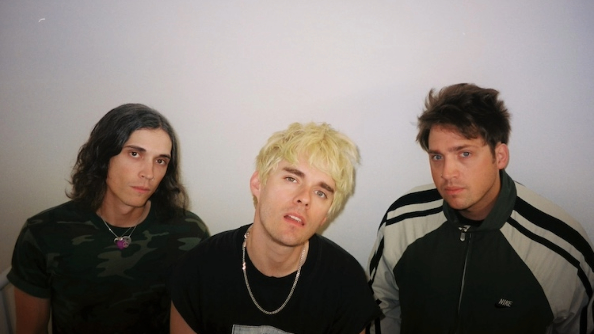 Integrantes da banda Waterparks posando para foto promocional com expressão séria.