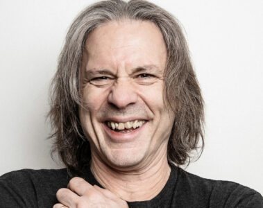 Bruce Dickinson sorrindo em foto de estúdio