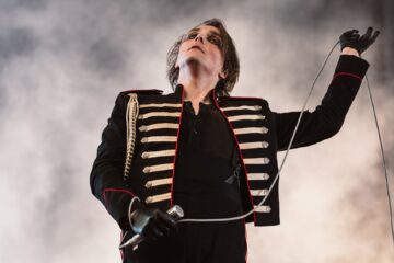 Gerard Way performando com uniforme militar preto no palco durante show do My Chemical Romance. Foto por Kelly Mason para Rock Sound.
