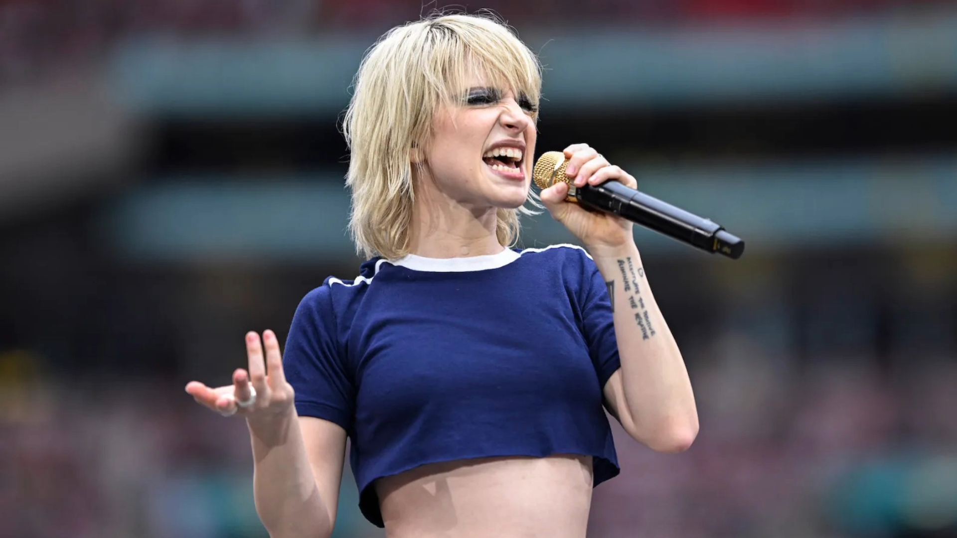 Hayley Williams cantando ao vivo em 2024 com microfone dourado