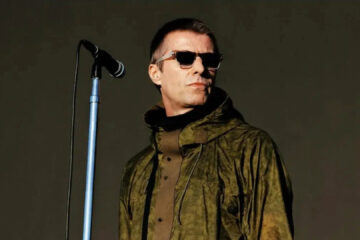 Liam Gallagher em apresentação no Heaton Park, em Manchester, usando jaqueta verde e óculos escuros
