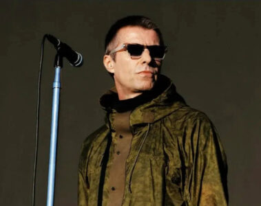 Liam Gallagher em apresentação no Heaton Park, em Manchester, usando jaqueta verde e óculos escuros