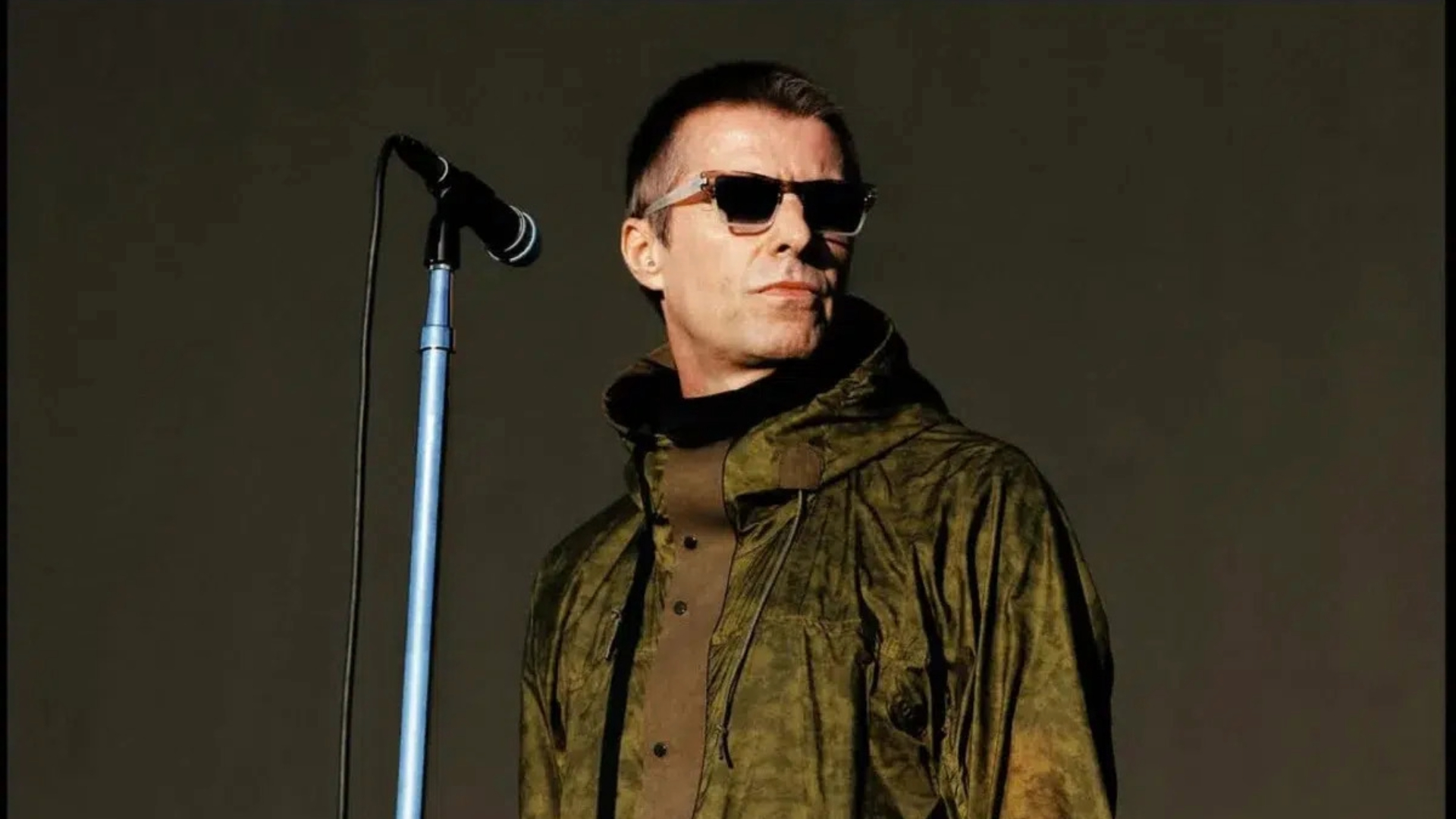 Liam Gallagher em apresentação no Heaton Park, em Manchester, usando jaqueta verde e óculos escuros