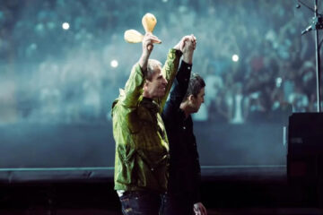 Liam e Noel Gallagher de mãos dadas no retorno do Oasis aos palcos em Cardiff
