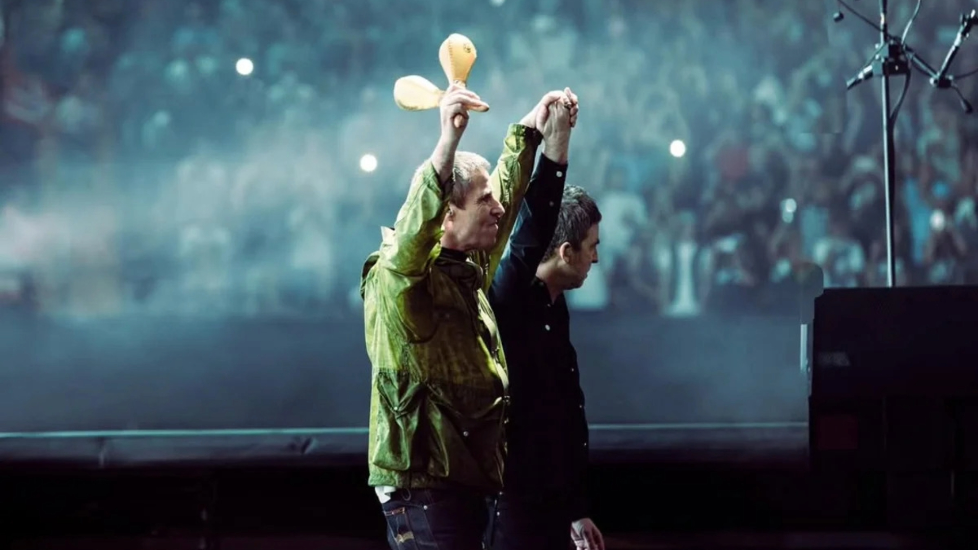 Liam e Noel Gallagher de mãos dadas no retorno do Oasis aos palcos em Cardiff