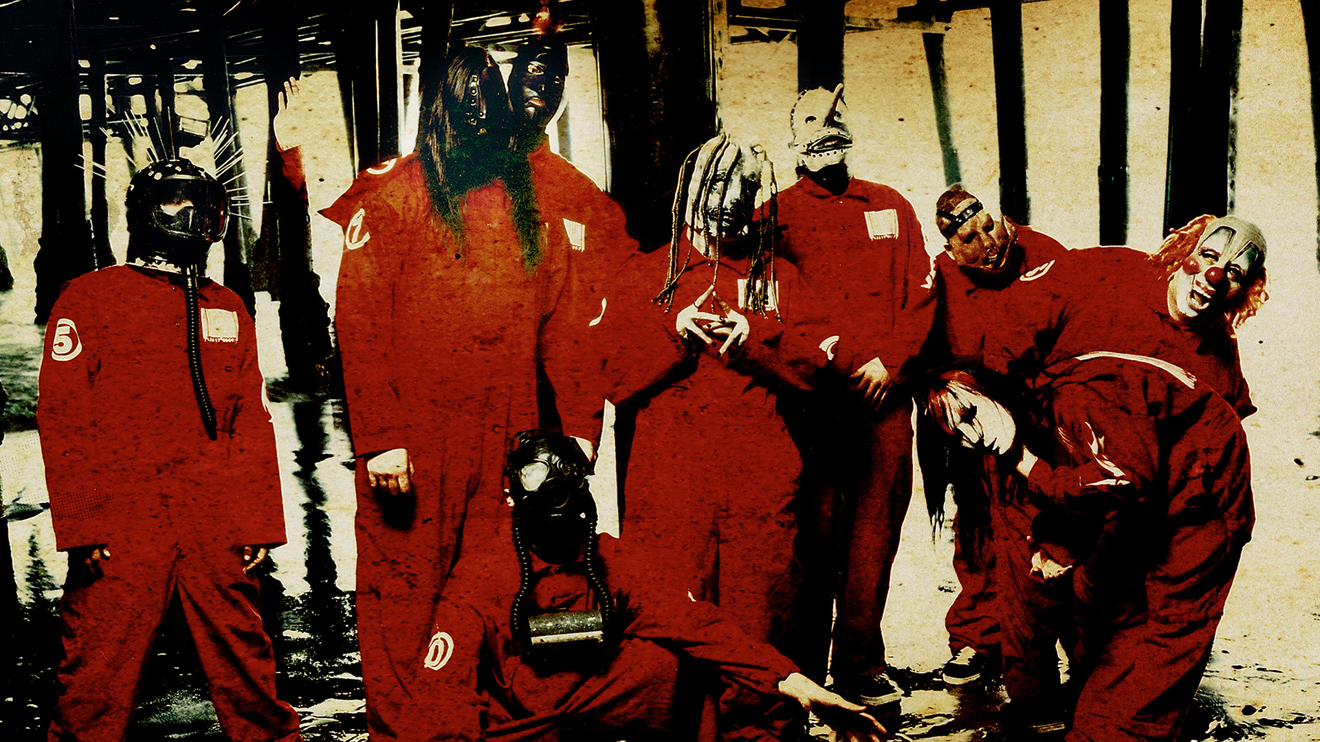 Slipknot em foto promocional com máscaras e macacões vermelhos, durante a era do álbum de estreia, 1999