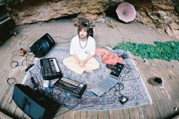 Kevin Parker em estúdio improvisado com equipamentos de gravação, teclados e sintetizadores ao redor