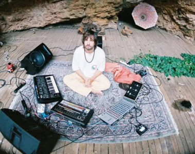 Kevin Parker em estúdio improvisado com equipamentos de gravação, teclados e sintetizadores ao redor