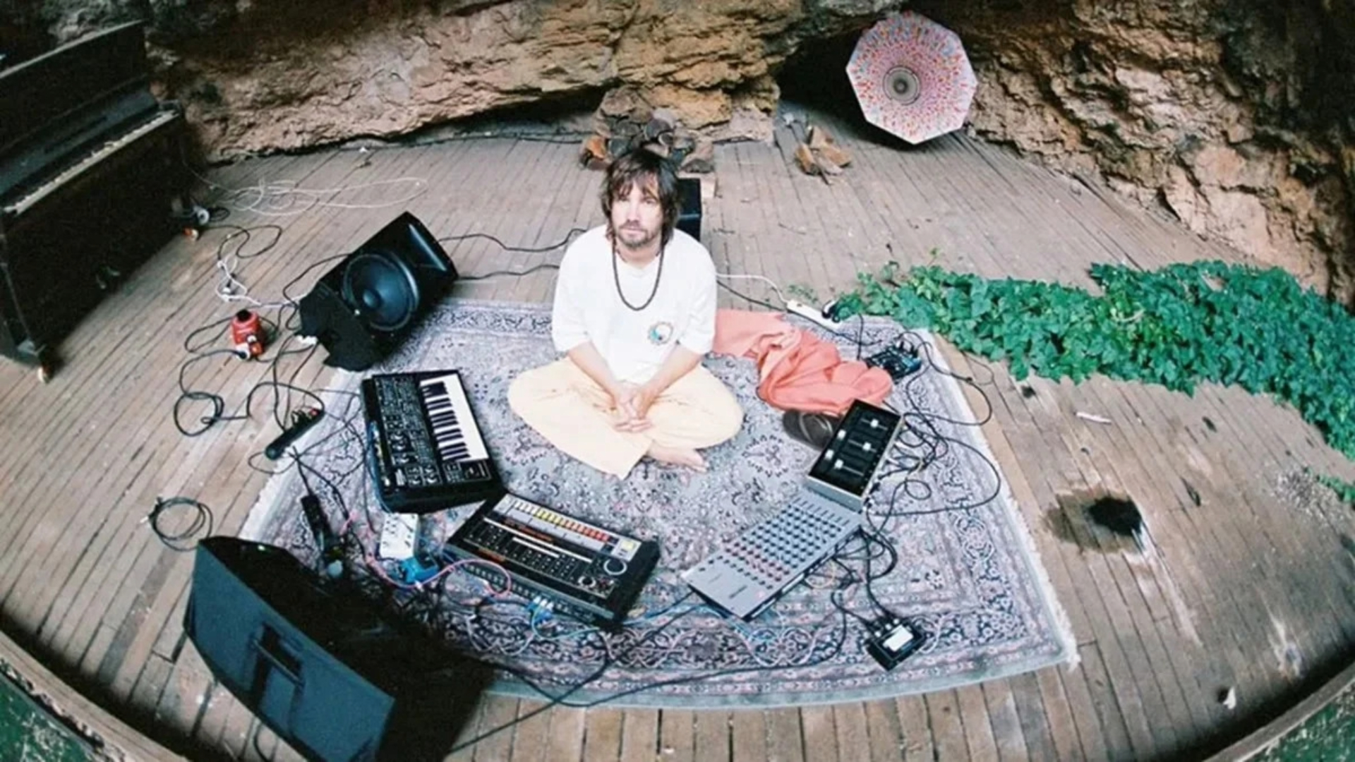 Kevin Parker em estúdio improvisado com equipamentos de gravação, teclados e sintetizadores ao redor