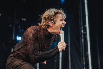 Vocalista do Cage the Elephant se apresentando no Lollapalooza 2025, em performance energética e intensa, foto por Josh Druding.