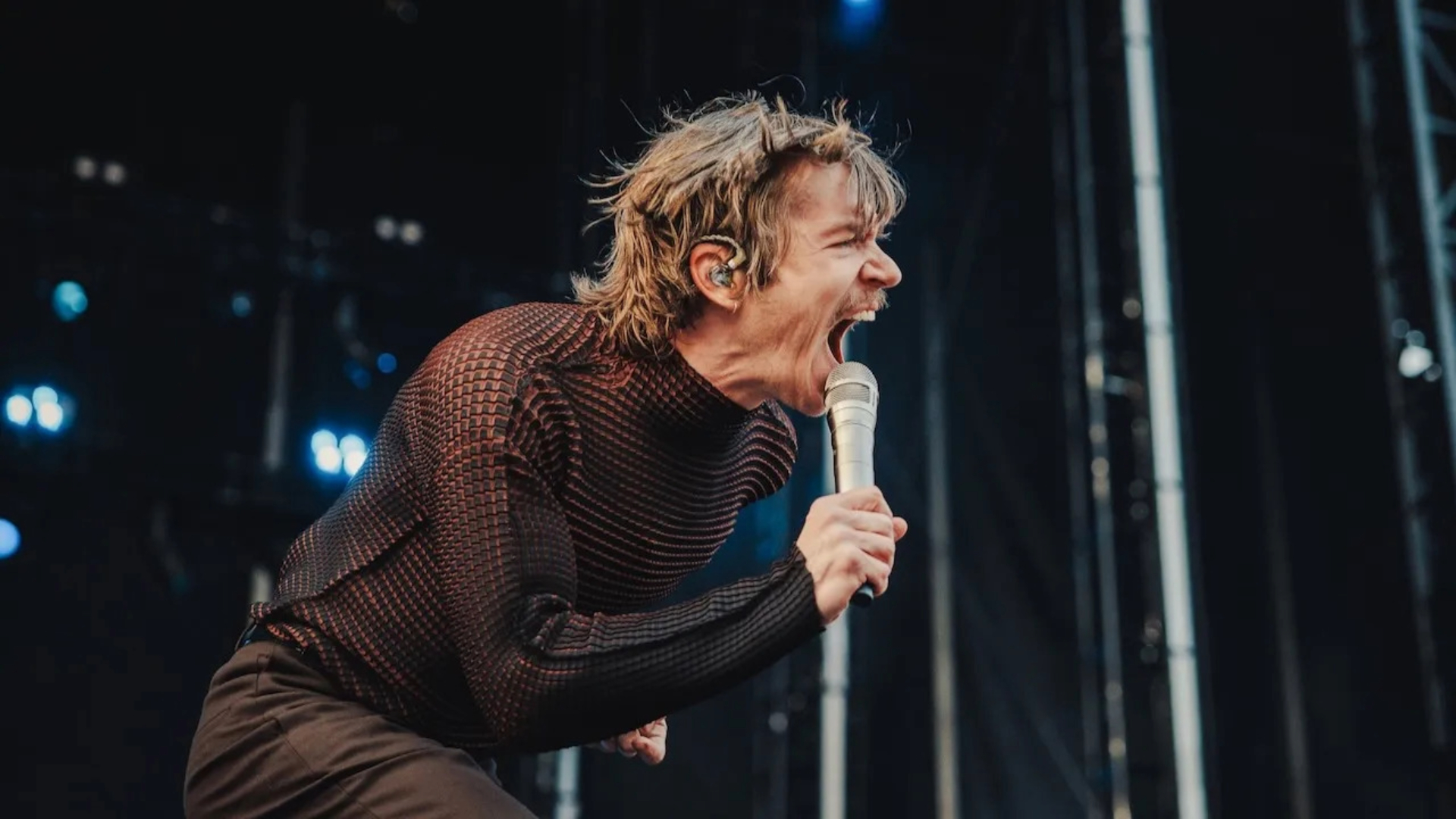 Vocalista do Cage the Elephant se apresentando no Lollapalooza 2025, em performance energética e intensa, foto por Josh Druding.