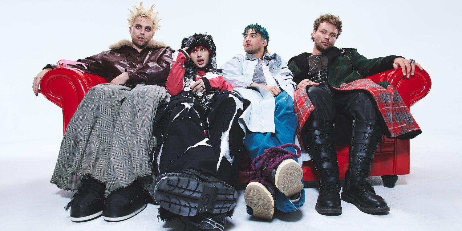 Banda 5 Seconds of Summer em ensaio promocional do álbum Everyone’s A Star! (2025), sentados em sofá vermelho com figurinos conceituais.