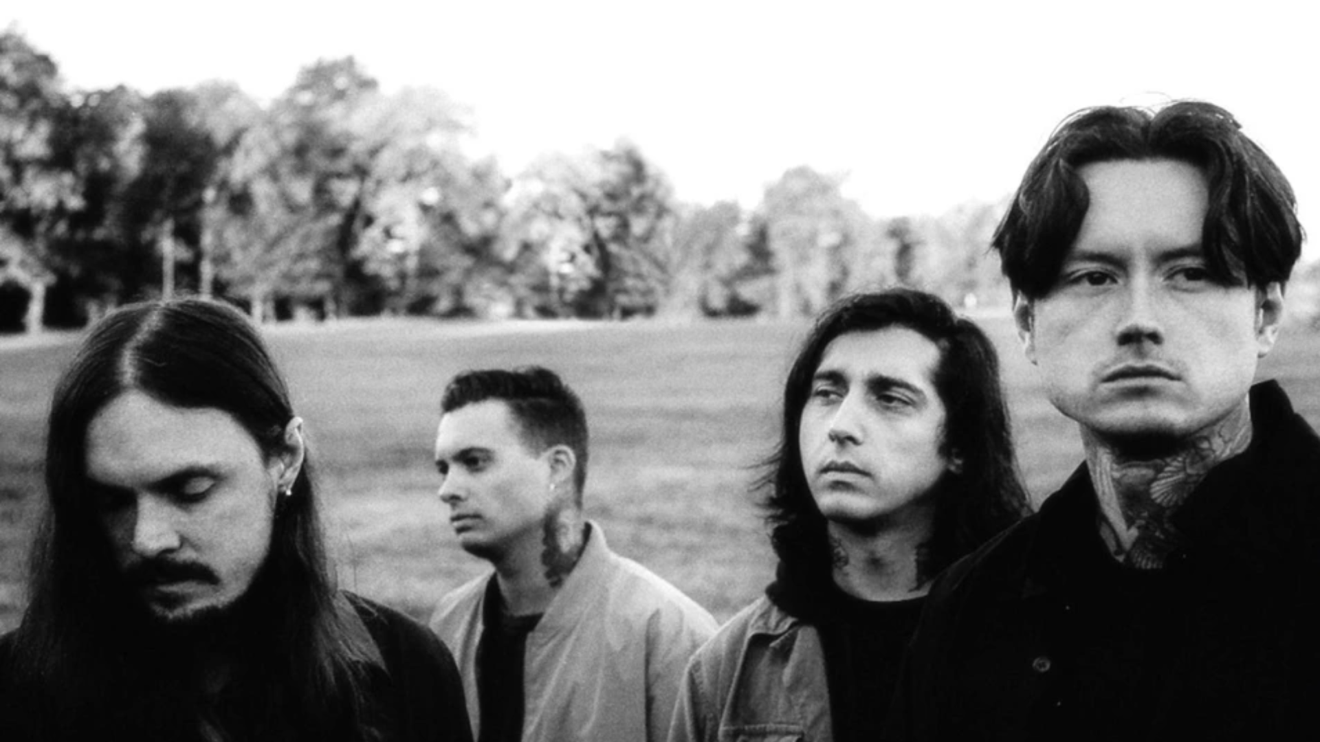 Os integrantes do Bad Omens posam em um campo, em foto promocional em preto e branco do single “Impose”.