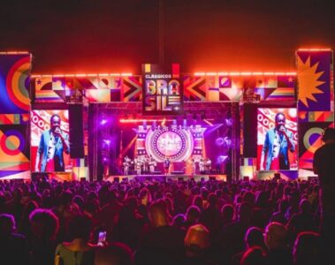Palco do Festival Clássicos do Brasil 2024 na Marina da Glória, iluminado à noite com público vibrante assistindo aos shows.