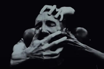 Cena do videoclipe de “As Alive As You Need Me To Be”, do Nine Inch Nails, com Trent Reznor cercado por várias mãos.