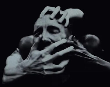 Cena do videoclipe de “As Alive As You Need Me To Be”, do Nine Inch Nails, com Trent Reznor cercado por várias mãos.