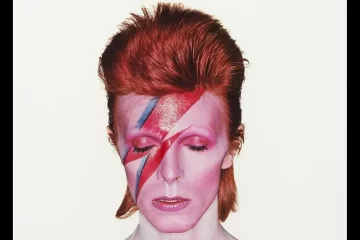 David Bowie com o rosto pintado com raio vermelho e azul na capa do álbum Aladdin Sane, foto tirada por Brian Duffy em 1973.