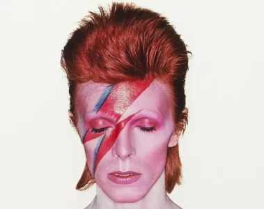 David Bowie com o rosto pintado com raio vermelho e azul na capa do álbum Aladdin Sane, foto tirada por Brian Duffy em 1973.