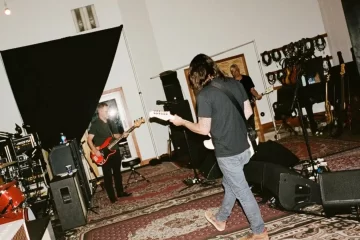 Integrantes do Foo Fighters tocam no Estúdio 606 durante ensaio, com guitarras, baixo e bateria.