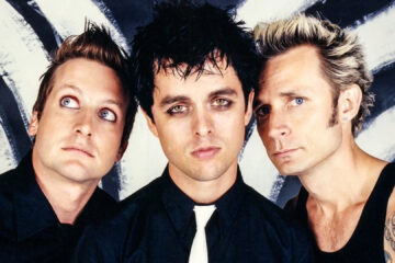 Foto da banda Green Day nos anos 2000, com Billie Joe Armstrong, Tré Cool e Mike Dirnt.