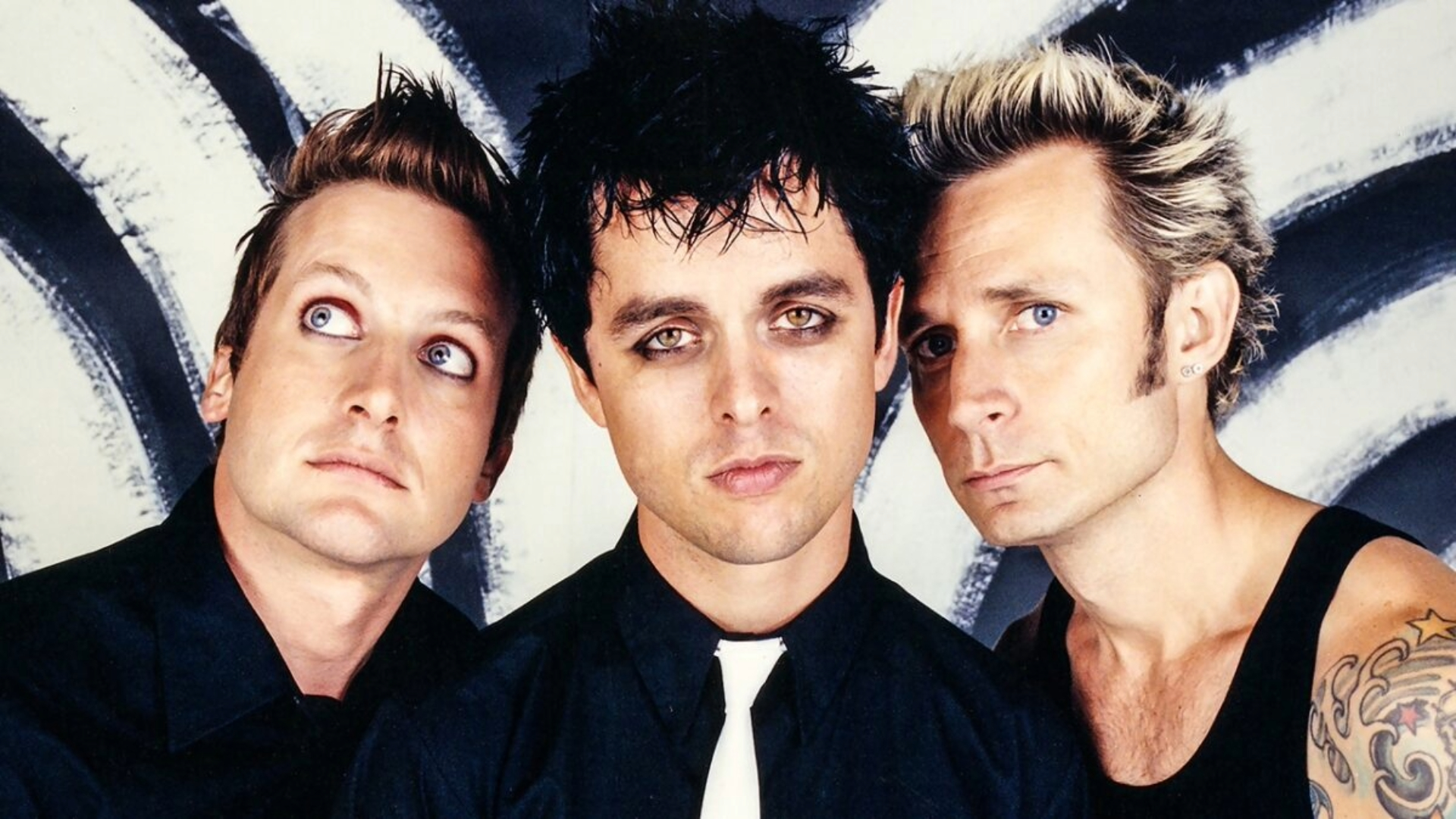 Foto da banda Green Day nos anos 2000, com Billie Joe Armstrong, Tré Cool e Mike Dirnt.