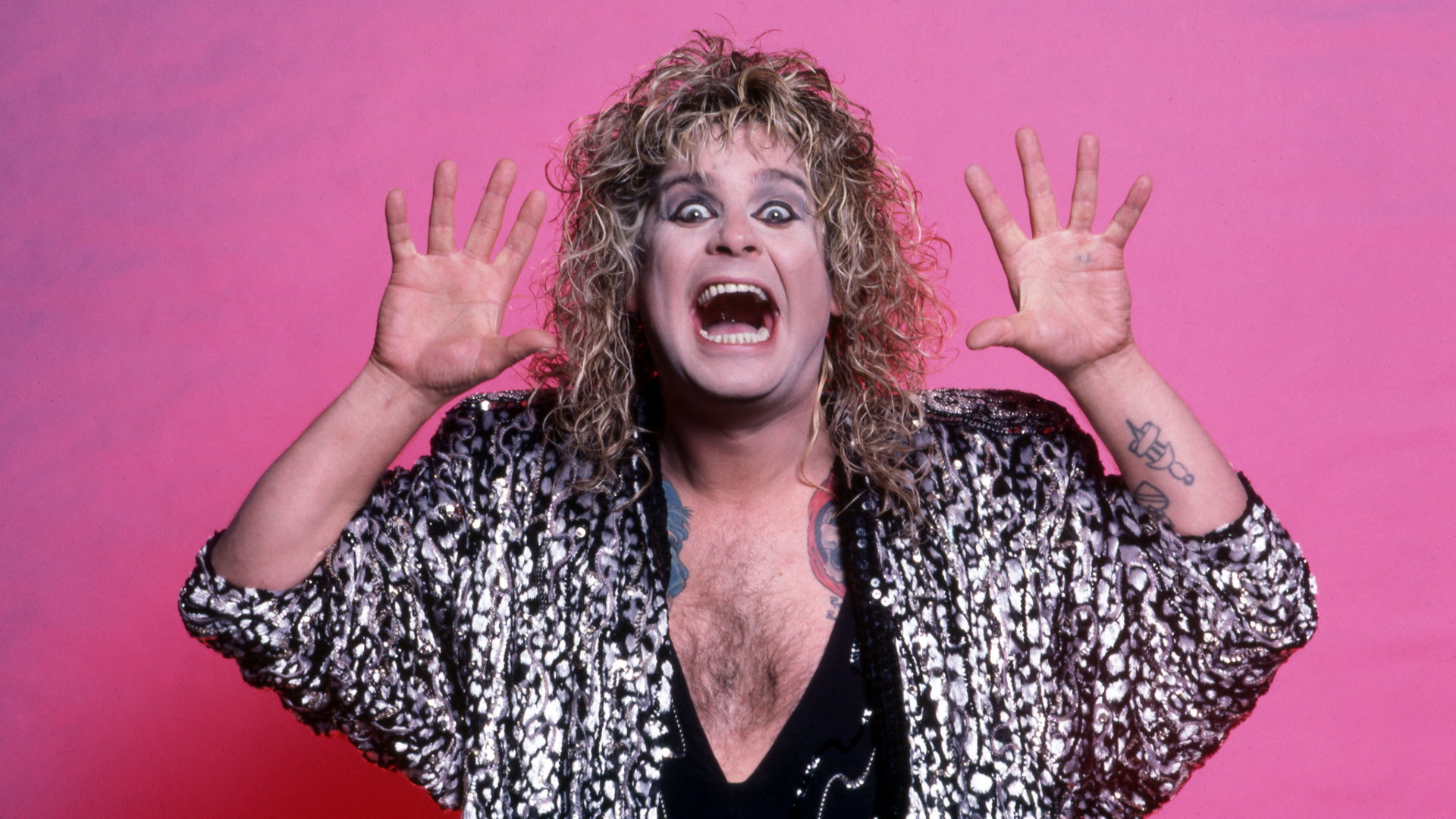 Ozzy Osbourne nos anos 80, em foto com expressão irreverente e figurino extravagante, o "Príncipe das Trevas" do heavy metal.