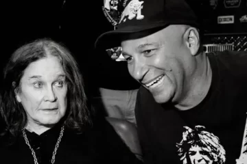 Ozzy Osbourne e Tom Morello sorrindo juntos nos bastidores após show do Black Sabbath.