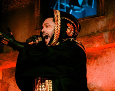 The Weeknd durante apresentação ao vivo, vestindo manto preto bordado, parte da turnê After Hours Til Dawn.