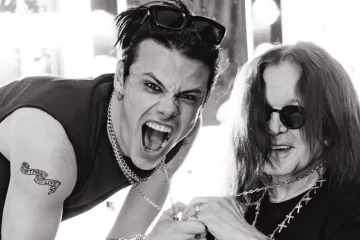 Yungblud e Ozzy Osbourne juntos em foto preto e branco, sorrindo e segurando correntes, mostrando amizade e conexão.