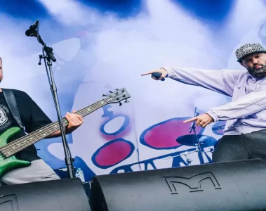 Fred Durst e Sam Rivers durante show do Limp Bizkit, em performance vibrante com luzes e fumaça no palco.