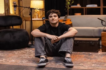 Nícolas Cândido sentado no estúdio Geração Pedreira durante as gravações ao vivo do single “Tudo Sobre Nós” (Créditos: Natália Melo)