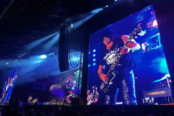 Slash tocando guitarra durante o show do Guns N’ Roses no Allianz Parque em São Paulo, com solo cinematográfico exibido no telão do palco.