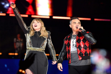Taylor Swift e Robbie Williams se apresentam juntos no palco durante show em Londres.