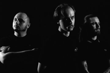 O trio bielorusso Molchat Doma está vindo ao Brasil para um show único em São Paulo. Conheça cinco músicas para entender a atmosfera sombria e pós-soviética da banda.