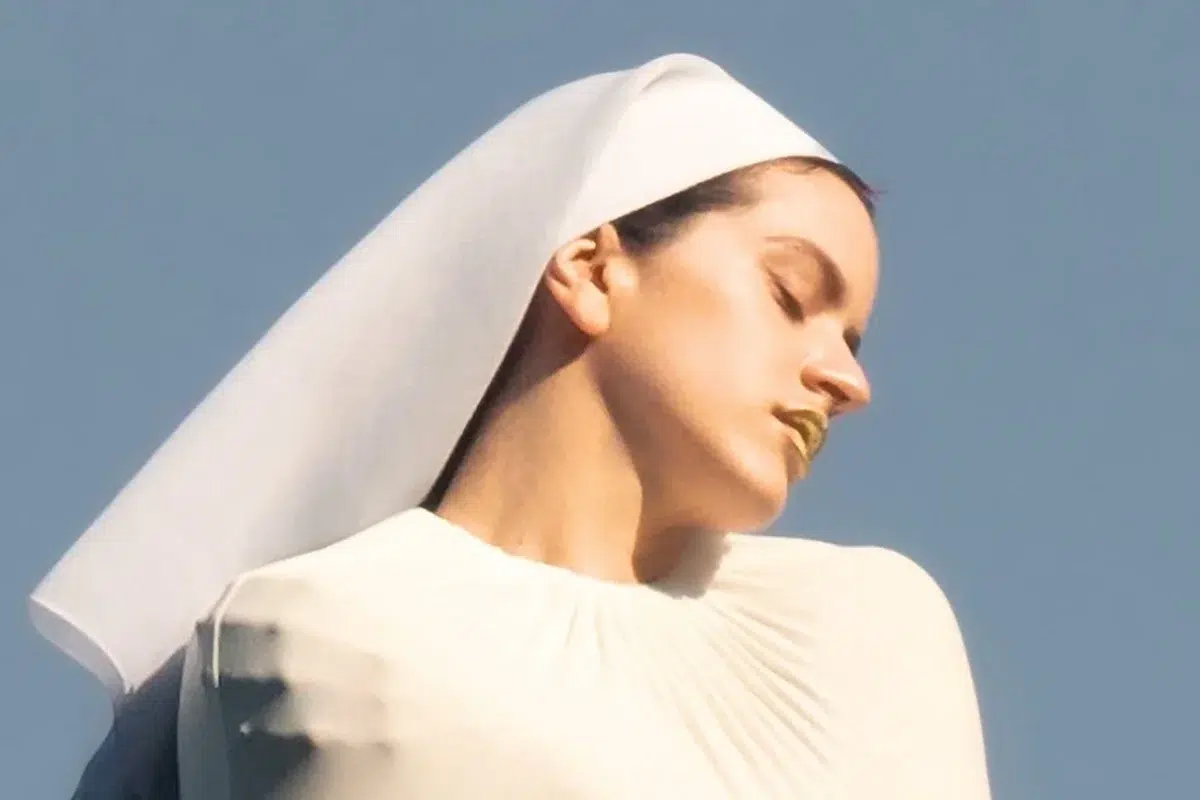 Rosalía vestida de branco com véu, em foto de divulgação do álbum Lux.