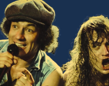 Brian Johnson e Angus Young do AC/DC durante apresentação ao vivo, com expressões intensas e iluminação dramática.
