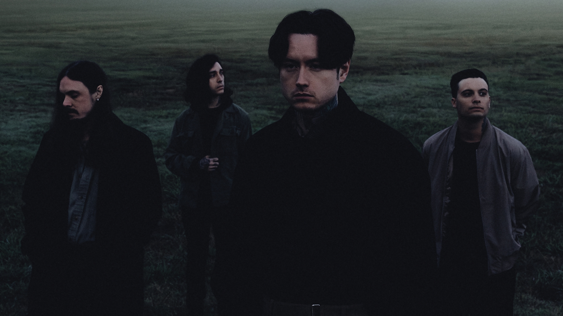 Foto escura e atmosférica do Bad Omens em um campo enevoado, com os quatro integrantes posando de forma séria, em tons frios e clima melancólico.