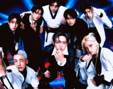 Grupo Stray Kids posando em estúdio com iluminação futurista, vestindo roupas em preto e branco, em foto promocional de 2024.