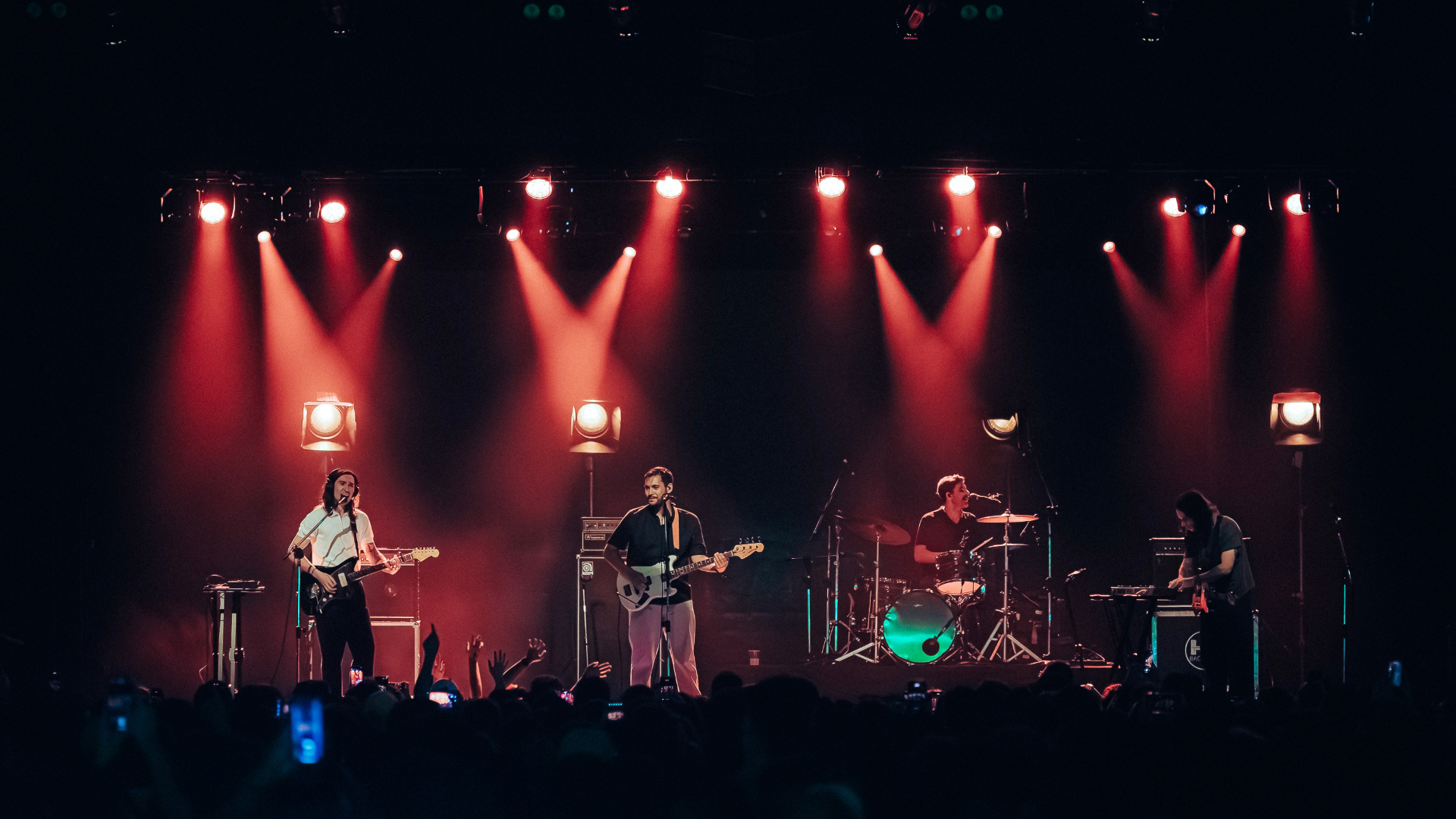 Terno Rei ao vivo em São Paulo durante show de encerramento da turnê, com iluminação vermelha e público lotado.