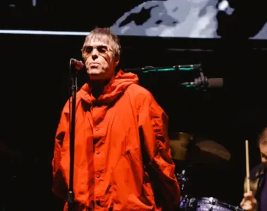 Liam Gallagher usa parka vermelha e canta em frente ao microfone durante show do Oasis em São Paulo.Liam Gallagher durante o último show do Oasis em São Paulo, no Allianz Parque, durante a turnê “Live ’25”. (Foto: Patrícia Devoraes / Brazil News)