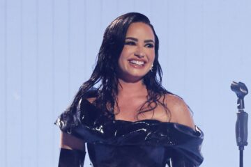 Demi Lovato sorrindo durante apresentação ao vivo, em foto de Mike Coppola, anunciada no Rock in Rio 2026.
