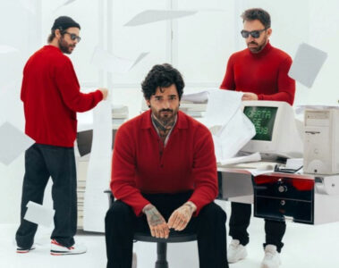 Integrantes da Fresno em estúdio branco, vestindo roupas vermelhas, com papéis voando e computador antigo exibindo “Carta de Adeus” na tela.