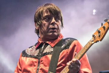 Baixista se apresenta ao vivo no palco, durante show de rock britânico