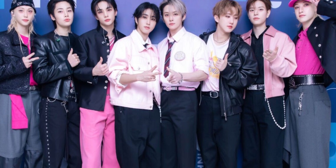 Foto do grupo Stray Kids posando juntos em evento, usando roupas em tons de preto e rosa — X/Reprodução.
