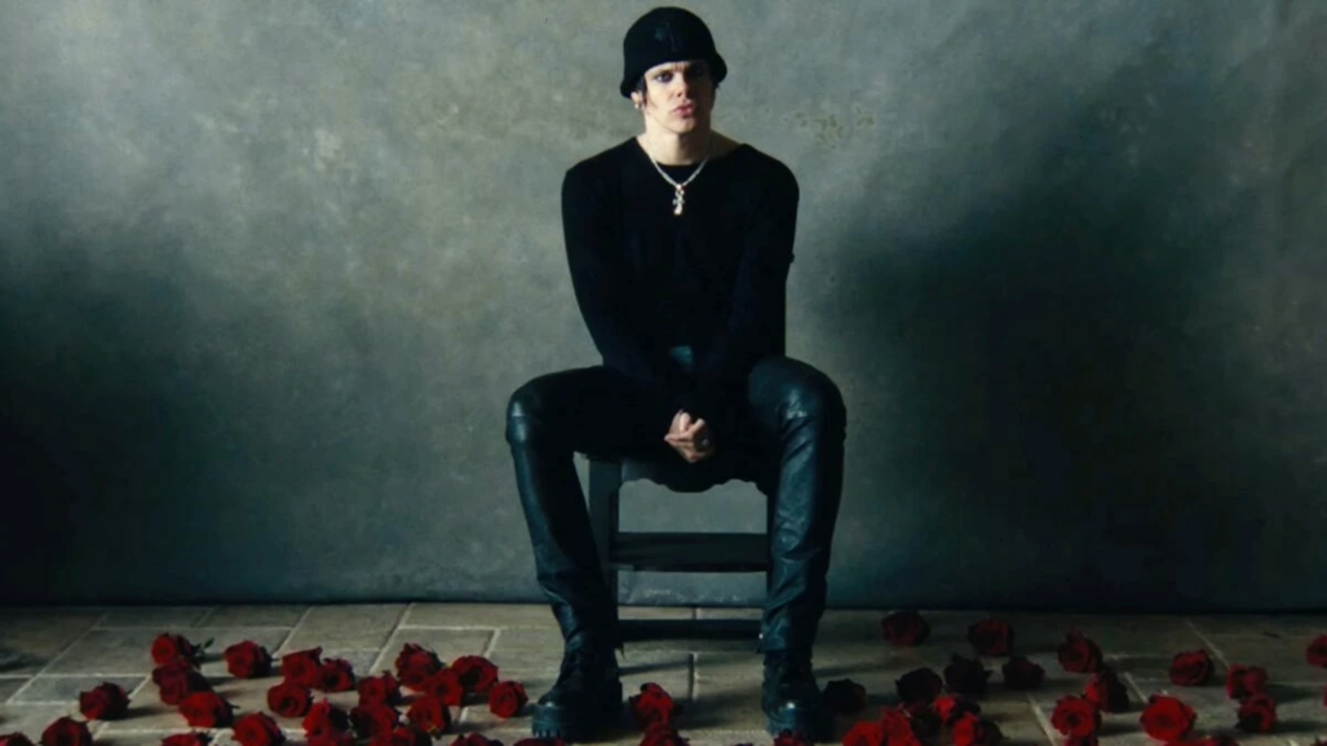 YUNGBLUD sentado em cadeira em cenário escuro na versão acústica de “Zombie”